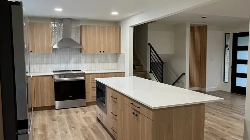 Remodelled kitchen with island, custom cabinetry and wood floors